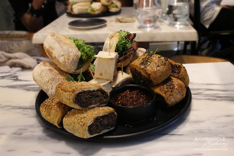 Cafe de la Ville - Mini sausage rolls, spinach and ricotta rolls, mini baguettes with poached chicken, slow roasted tomatoes, shredded carrot, fresh herbs, citrus mayo