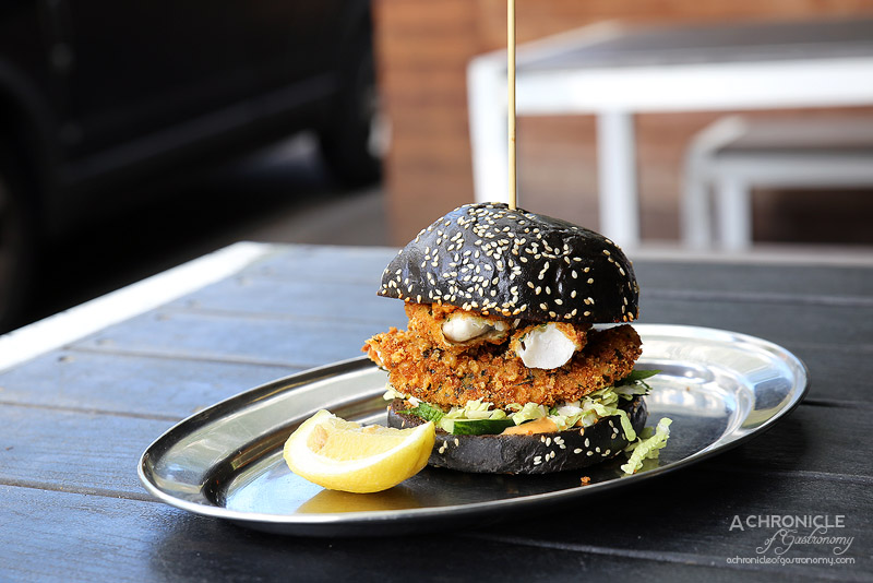 Tank Fish and Chips - Parmesan crumbed flathead fillet, mint and cucumber slaw, harissa mayo on a squid ink brioche bun